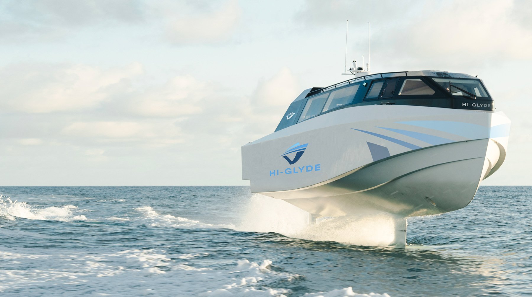 White and blue motorboat anchored in shallow ocean water with waves and cloudy sky